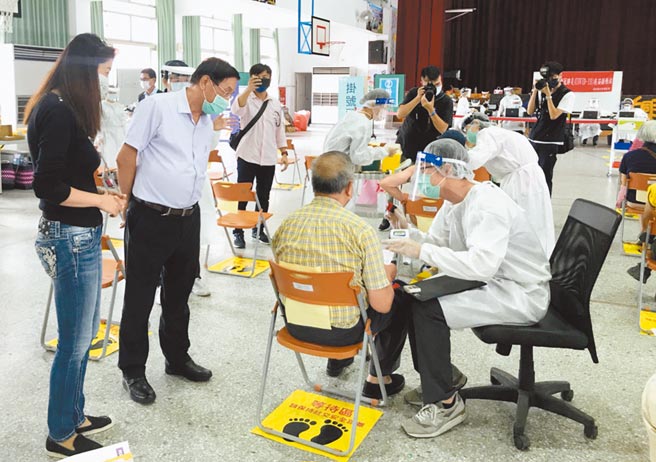 南投县长林明溱（左二）、立委许淑华（左一），昨天到南投市漳兴国小大型接种站，了解老人家接种情形，并向陪同家属致意。（南投县政府提供／陈世宗南投传真）