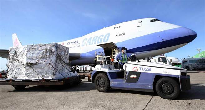 貨機停妥後，地勤人員將裝有疫苗的貨盤卸下。（范揚光攝）
