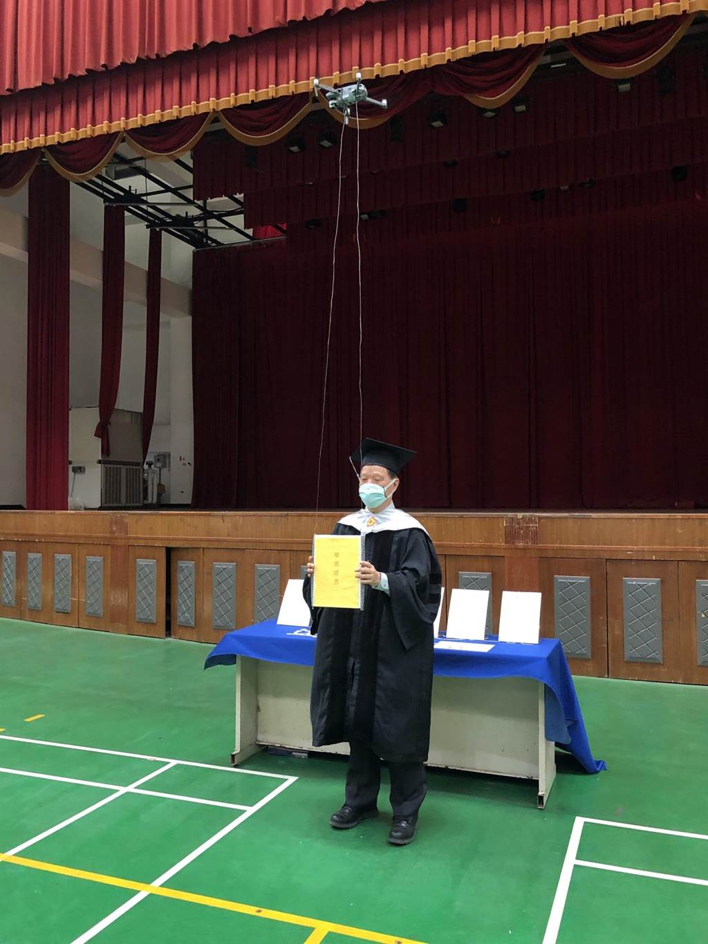 遠東科大校長王元仁將畢業證書放在無人機上，飛遞給另一端的畢業生。（遠東科大提供／劉秀芬台南傳真）