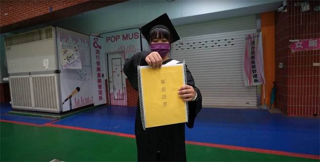 远东科大观光英语系蔡宛蓁接过无人机传送来的毕业证生。（远东科大提供／刘秀芬台南传真）