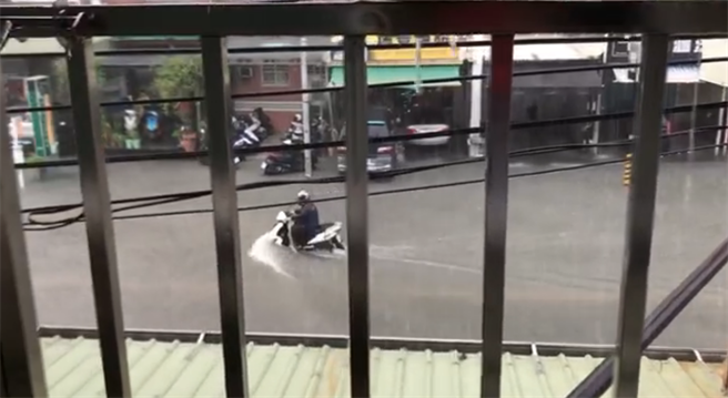 图为高雄本馆路淹水。机车激起超大水花。（翻摄自 我是高雄人）