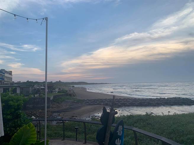 浅水湾在地店家拍下海边的照片，指出仍有民眾无视三级警戒禁令，跨越封锁线踏上海滩看海，图片可见远处的海滩上仍有人点。（翻摄脸书社团《阮厝住三芝》）