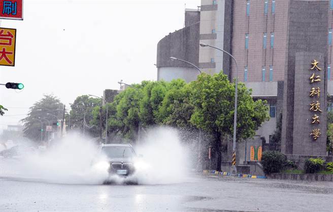 大仁科技大学前积水，轿车经过溅起大片水花。(林和生摄)