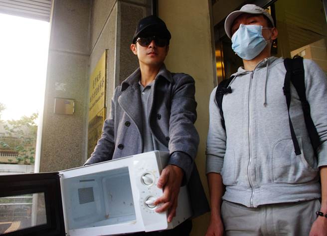 当年郑男微波炉烹猫一案，检方传讯郑姓猫饲主（左）与其陈姓室友（右）了解案情，饲主特地带着凶器微波炉出庭，为死去的猫叫屈。（中时资料照）