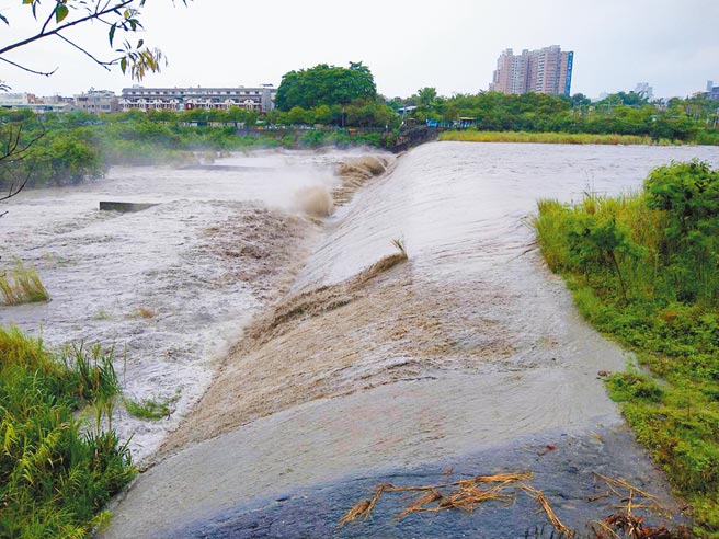 嘉义县山区连日降雨，八掌溪水流至道将圳拦河堰形成瀑布景观。（张亦惠摄）
