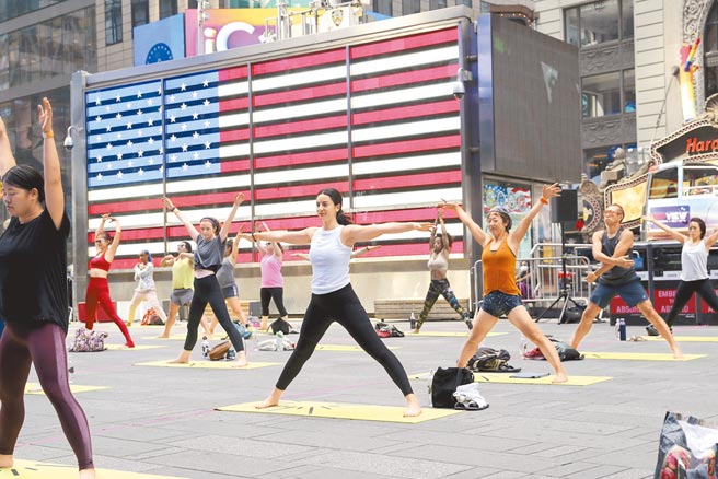 隨著疫苗接種普及，美國民眾在當地時間6月20日，於紐約時報廣場練習瑜伽，迎接夏至到來，並加大間隔防疫。（中新社）