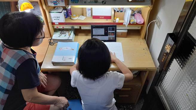 苗栗公馆国小祖孙一起使用平板电脑线上学习。（明基基金会提供／谢明俊苗栗传真）