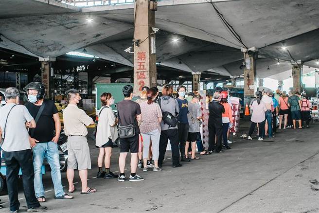 农委会宣布未来无论员工及承销商皆须持有快筛阴性证明才能进入场域从事交易，第一果菜市场23日拍卖结束后，许多承销人员大排长龙登记，准备赴万大国小筛检站筛检。(郭吉铨摄)
