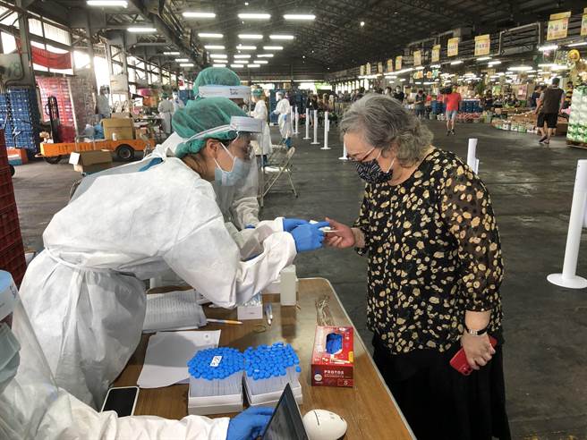 台中果菜公司董事长庄乃慧（右），今天上午第一位登记接受快筛。（陈世宗摄）