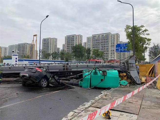 工地巨型打桩机突倒塌，不偏不倚压扁一台马路上的轿车。（照片来源：微博）