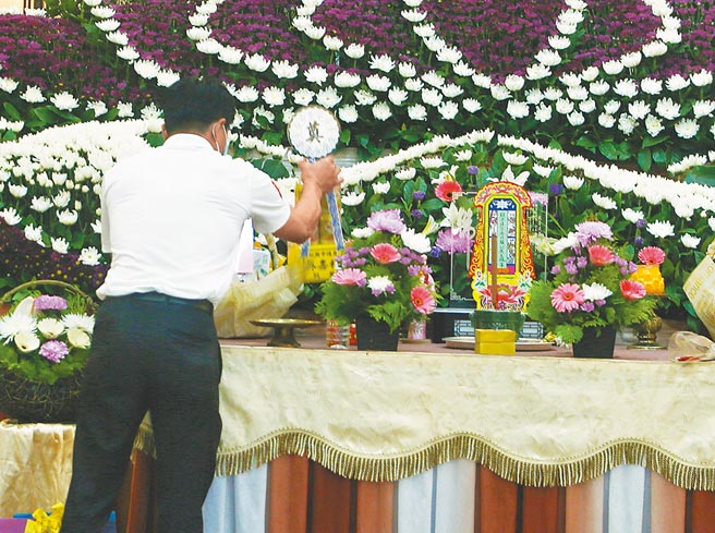 殡葬服务人员处理遗体面临染疫高度风险，为维护其职业安全，在内政部积极争取下，中央流行疫情指挥中心22日已同意将实际处理遗体的殡葬服务人员，纳入第2类防疫人员，优先接种疫苗，图为礼仪公司员工布置追思会场。（陈怡诚摄）