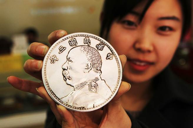 民眾手持「袁大头」。（中新社资料照片）