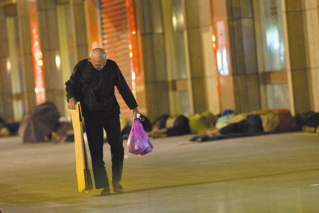 新冠肺炎本土疫情持續蔓延，繼北農、士林養護機構群聚感染後，台北車站亦傳出8名街友確診，台北車站23日深夜仍能看見大批街友睡在周邊。（杜宜諳攝）