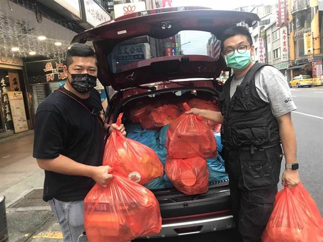 作家林立青（右）開車與草爺親自運用抗疫物資包。（紅心字會提供）