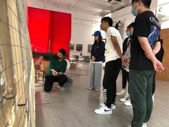 台籍教师李一进（蹲者）为学生讲解。（受访者提供）