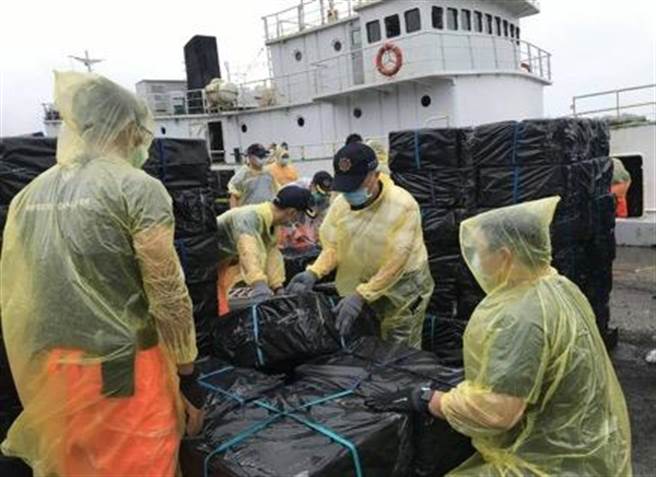 专案小组人员冒雨清运私菸。（海巡署侦防分署嘉义查缉队提供／张亦惠嘉县传真）