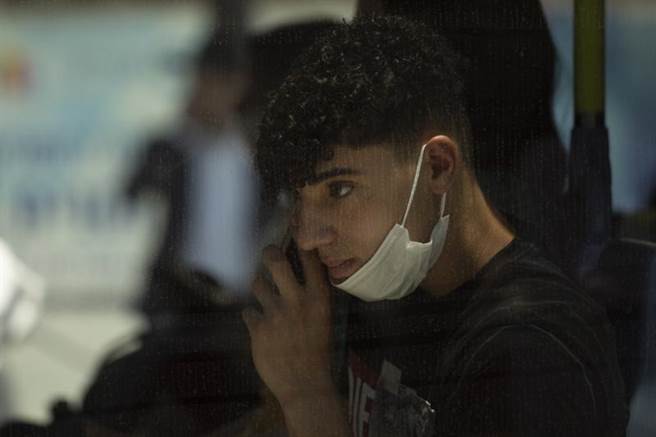 以色列恢復室內戴口罩規定。圖為一名搭乘耶路撒冷輕軌的少年。（圖／美聯社）