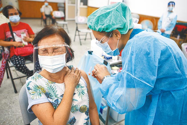 图为一位前往施打新冠疫苗的长者，紧闭双眼，心情似乎相当紧张。图／邓博仁