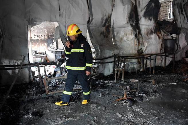 河南柘城縣6月25日火警致18死16傷，消防人員在現場勘查。（新華社）