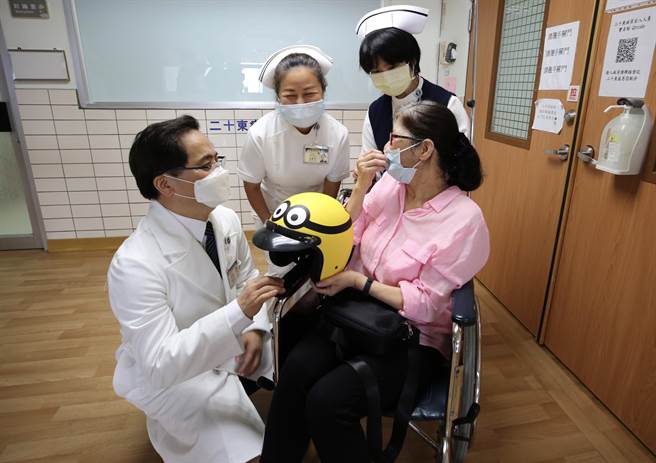 花莲慈院院长林欣荣（左起）与重症加护内科病房主任陈逸婷、医务部主任吴雅汝与护理部主任锺惠君等团队成员，为「安全帽阿姨」林女士出院送上祝福，林女士也赠送安全帽，感恩祝福。（慈济医院提供／王志伟花莲传真）