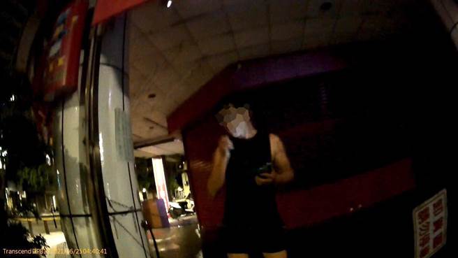 年輕男子在住家騎樓下，未戴口罩忘我的滑手機被警方當場撞見。（翻攝照片／石秀華高雄傳真）