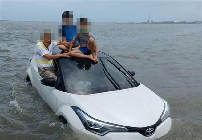 爺孫3人挖蛤蠣遇漲潮受困車頂，如水中行車揮手求援獲救。(彰化縣消防局提供)
