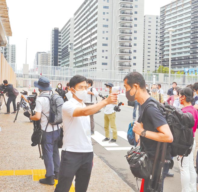 日本東京都等7都道府縣第三度解除「緊急事態宣言」，觀光景點人潮大增，連帶確診數也跟著上升。圖為工作人員為進入東京奧運村的人量體溫。（新華社）