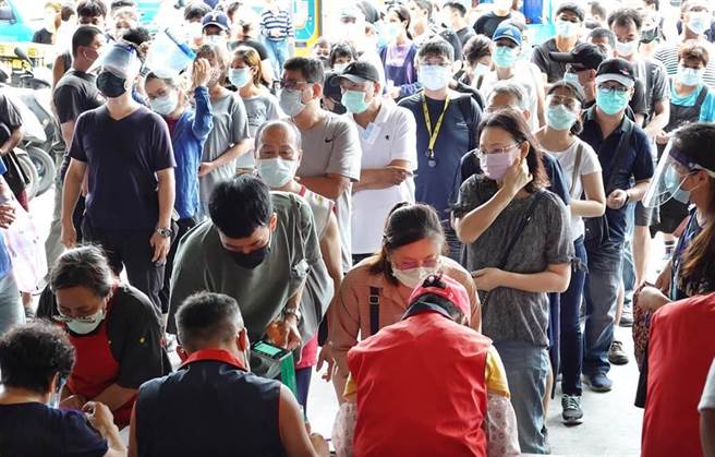 台北農產運銷公司爆發群聚感染，台北市長柯文哲29日表示，從過程中發現跨縣市疫調系統問題，需要做一個全國可以跨縣市的疫調系統。圖為北市環南市場29日再度出現大批人潮排隊登記搭防疫專車前往醫院施打疫苗。（資料照，姚志平攝）