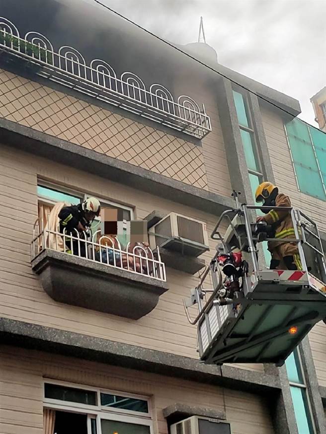 高市前镇区一处民宅今傍晚突传火警，母带7岁儿躲在阳台，云梯车升起救出母子。（翻摄照片／石秀华高雄传真）