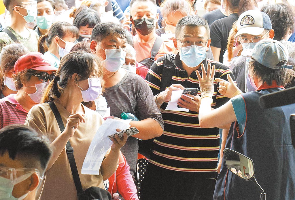 疫情3級警戒未解除，台北市環南市場29日出現大批民眾登記搭防疫專車前往醫院施打疫苗，排隊人擠人引發群聚質疑。（姚志平攝）