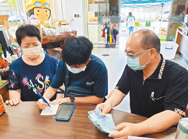 曾是寄养儿童的阿芬，拿着省吃俭用存下的10万元，在寄养妈妈邱招玲（左）陪同下，至屏东家扶捐款。（林和生摄）