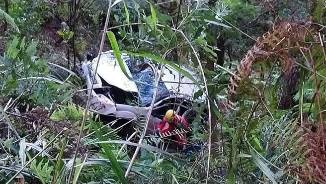 白色休旅车倒栽葱墬落山谷，警消下探救出3名伤者。（民眾提供／王文吉台中传真）