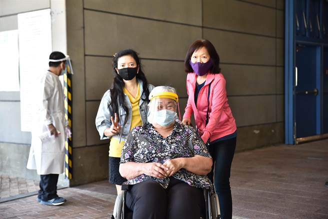 一位奶奶在進入漢神巨蛋接種莫德納疫苗前，拍照留念。（林瑞益攝）