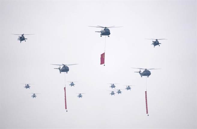 在中共建党百年庆祝大会上，悬挂党旗与标语的5架直-8L直升运输机是新近正式服役的两栖作战利器，未来将登上两栖攻击舰成为运送人员与装备的舰载机。在后方的是直-10直升机。（图／新华社）