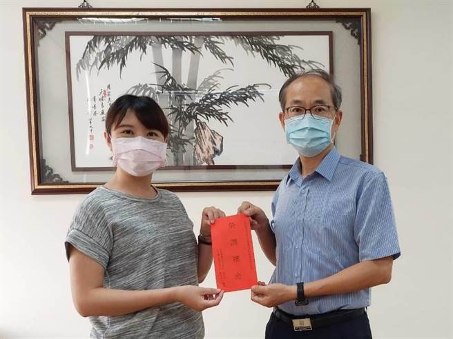 台南市白河警分局书记孙如宜（左）将核调佳里分局，白河分局长陈明宏（右）特别颁赠纪念品。（读者提供／张毓翎台南传真）