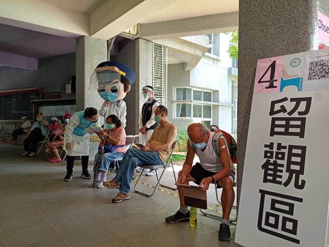 淡水警分局穿戴防疫装备的警察娃娃穿梭在新市国小疫苗接种站的排队人群里（淡水警提供／戴上容新北传真）