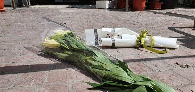 消防火調人員、彰化檢警今天都深入喬友大樓火場調查勘驗，檢警正深入在追查是否有疏失與人為縱火可能；大樓外廣場有民眾默默放上花束悼念不幸罹難的死者。（謝瓊雲攝）