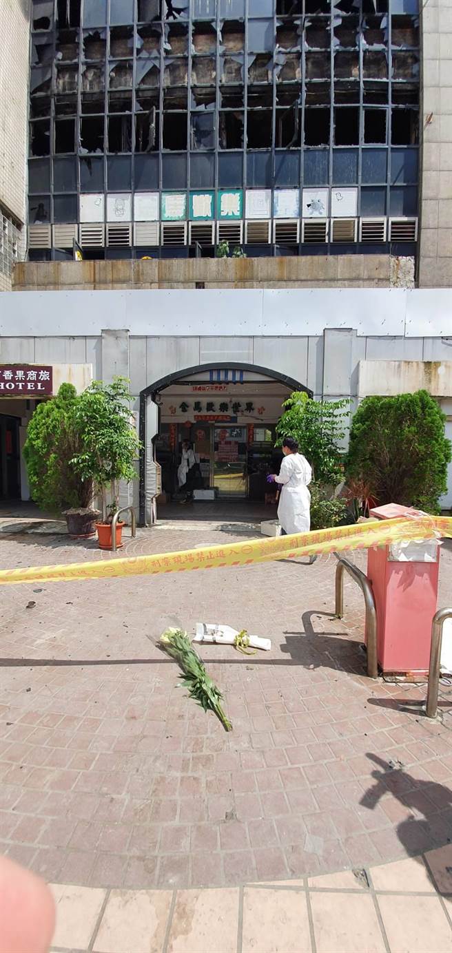 消防火調人員、彰化檢警今天都深入喬友大樓火場調查勘驗，檢警正深入在追查是否有疏失與人為縱火可能；大樓外廣場有民眾默默放上花束悼念不幸罹難的死者。（謝瓊雲攝）