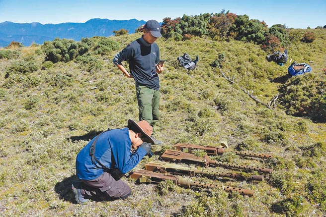 甘耀明（右）与朱和之重返空难现场，寻获美军B24轰炸机的50机枪。（沙力浪提供）