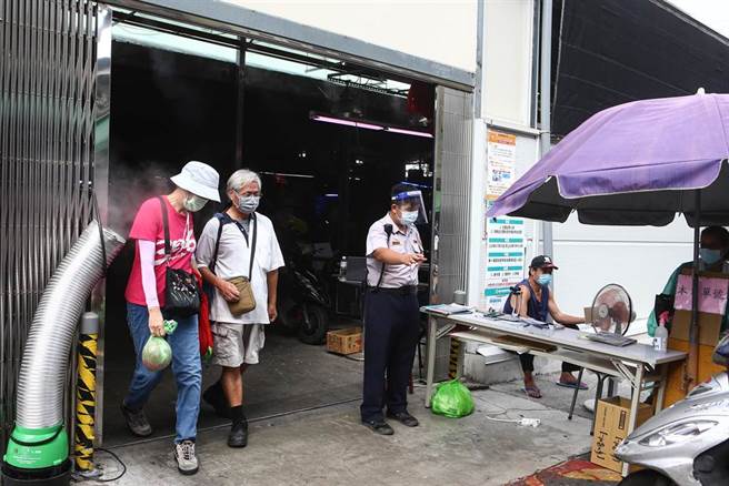台北市虎林街、永春市場周遭又爆出新冠肺炎30例確診，4日一早萬華區的富民街市場，在人流管制下，許多民眾作好最佳防疫出門買菜，市場也貼心的在出口處設置消毒設施，為民眾作清消。（鄧博仁攝）