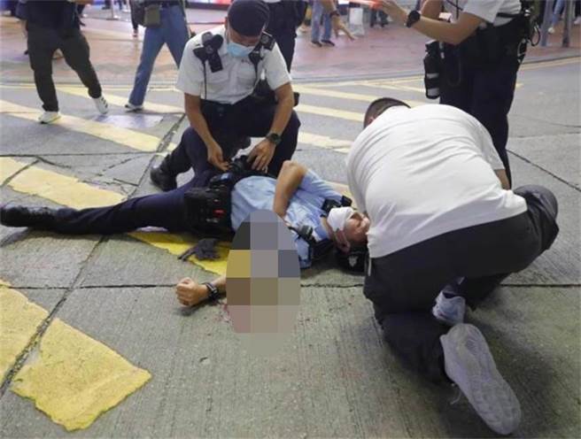 香港警务处处长萧泽颐表示，留意到七一铜锣湾男子刺警自戕事件后，有人继续在网上鼓动人袭警，今传出香港警方网路安全及科技罪案调查科拘捕1男1女。图为事发当时遇刺倒地的员警。（东网）