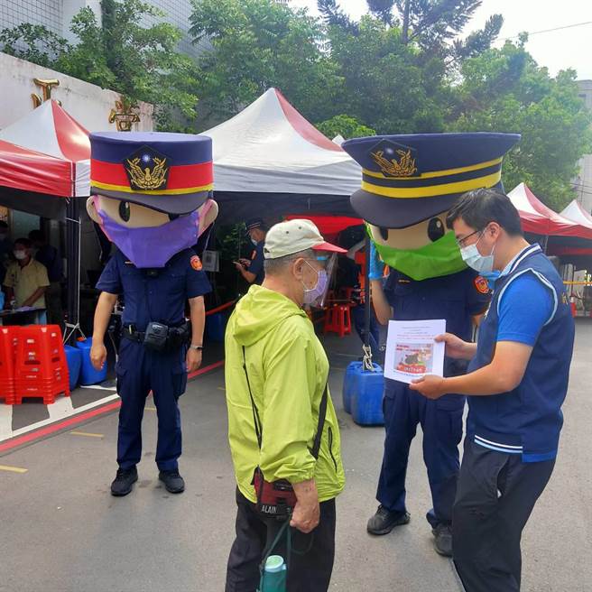 新北市中和警分局藉由高龄长者等候施打疫苗的期间，以警察娃娃戴口罩，发放诈欺相关文宣的方式，向高龄长者逐一宣导防诈观念，期许能阻止诈骗行为。（中和警分局提供）