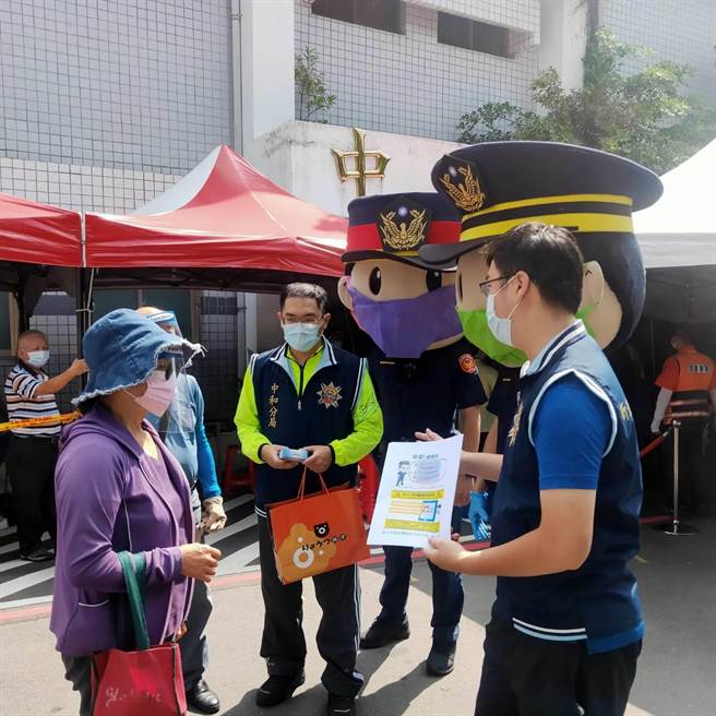 新北市中和警分局藉由高龄长者等候施打疫苗的期间，以警察娃娃戴口罩，发放诈欺相关文宣的方式，向高龄长者逐一宣导防诈观念，期许能阻止诈骗行为。（中和警分局提供）