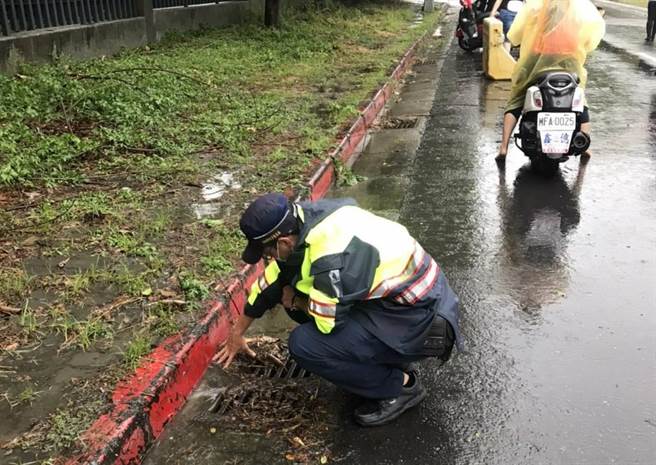 高雄市5日午后下了一场豪雨，警方到冈山区本工三路与本工环东路口的易积水路查看。（高雄市水利局提供／林瑞益高雄传真）