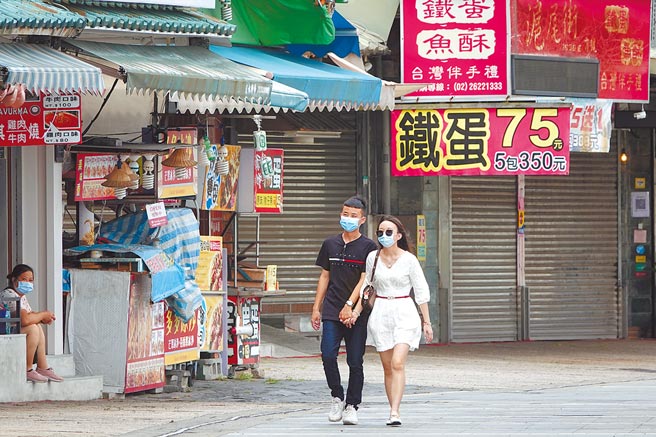 朝野立委不分蓝绿昨都疾呼，内需经济恐怕已快撑不下去，三级警戒再延长下去将有倒闭潮。图为对比涌现出游人潮的八里左岸，右岸的淡水4日人潮稀疏，一整排店家拉下铁门未营业。（黄世麒摄）