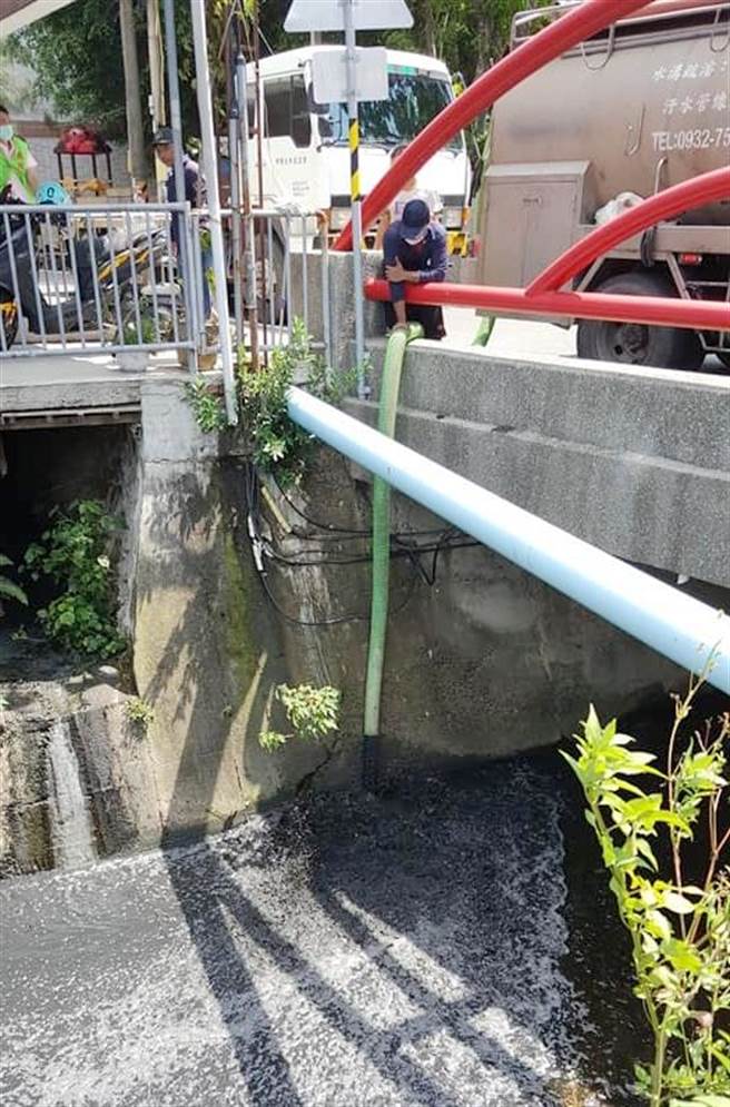 呂姓網友拍下1輛水肥車，將車子停在橋上，一名男子拉著管線將水肥直接倒入排水溝內。（取自「水上人家 幸福家人」臉書社團∕呂妍庭嘉義傳真）