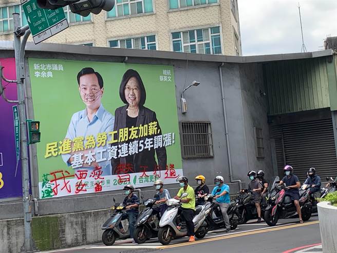 民进党新北市议员李余典与总统蔡英文悬挂在三重永安北路一段与国道路二段交叉口附近的看板遭人恶意涂鸦。（李余典服务处提供）