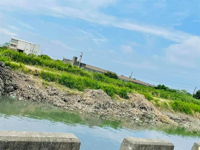 伸港六股水圳岸邊又見堆爛泥雜草，就怕颱風下雨又衝落水，縣府表示只是暫置，包商承諾一定會運走。（賴清美提供／吳敏菁彰化傳真）