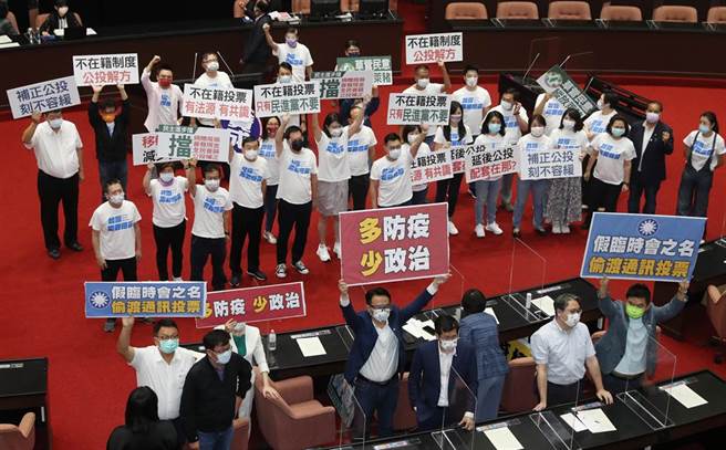 国民党立法院党团提案召开临时会，修《公投法》实施不在籍投票；立法院7日召开谈话会，讨论是否召开临时会时，蓝、绿立委各自举标语表达立场，最终，民进党团以人数优势封杀该提案，宣告不在籍投票胎死腹中。（刘宗龙摄）
