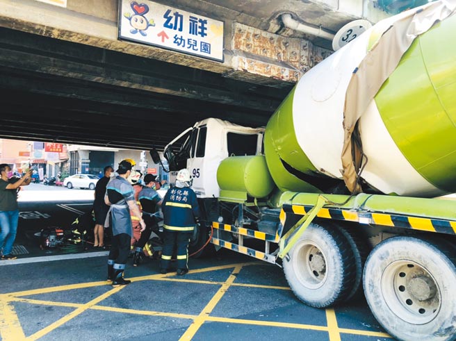 彰化市天祥路中央陆桥下，林男驾驶混凝土车，因不熟路况与陆桥高度，从南往北硬闯卡住，司机被挤扁在驾驶座伤重命危中。（彰化踢爆网提供／吴敏菁彰化传真）